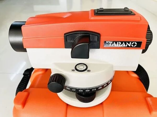 An orange automatic level with a glass circular bubble level vial