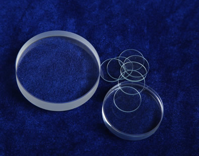 Six pieces of polished surface glass discs in different thickness are on the desk.