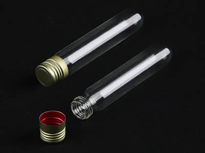 A closed and an opened glass test tube with aluminum screw stopper on the black background.