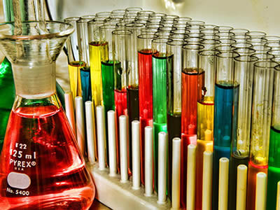 Several glass test tube with different solvents on the test tube racks.