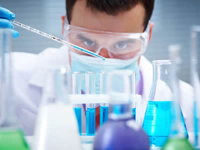 A man is dripping the liquid into the glass test tube.