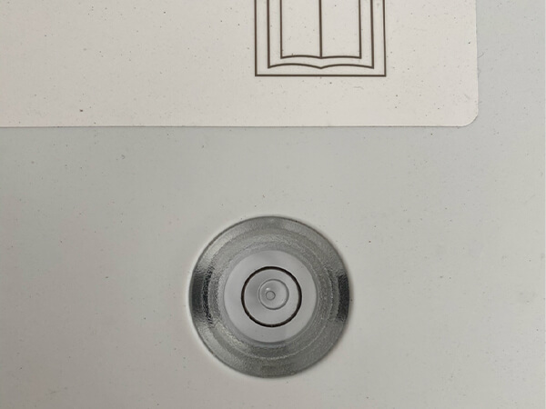 A plastic bubble level vial on the washer panel