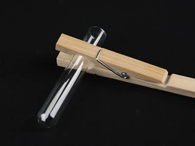 A test tube holder with a glass test tube on the black background.
