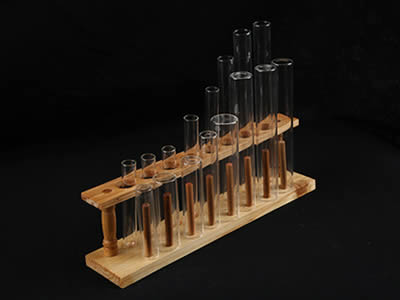 A wooden test tube racks with several galss test tubes on the black background.