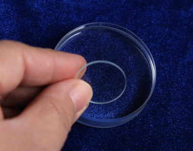 Two pieces of glass discs on the desk, one 0.5 mm thickness, another 5 mm thickness.